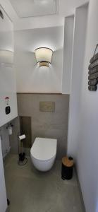 a bathroom with a toilet with a light on the ceiling at L'écume du fort , Face à la mer, Coucher de soleil in Le Portel