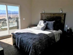 a bedroom with a large bed with a large window at Barnwood Chateau With 2 Master Suites Hot Tub in Salida