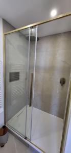 a shower with a glass door in a bathroom at L'écume du fort , Face à la mer, Coucher de soleil in Le Portel