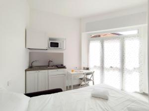 a white kitchen with a white bed and a table at Residence Mario Bianco in Milan +29 photos