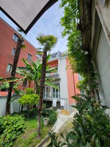 a courtyard with palm trees and a building at Residence Mario Bianco in Milan