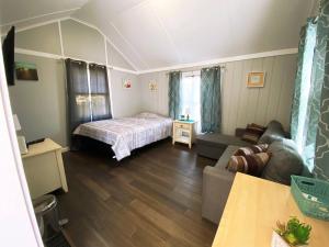 a living room with a bed and a couch at Willows Studio Cottage in Dennis Port