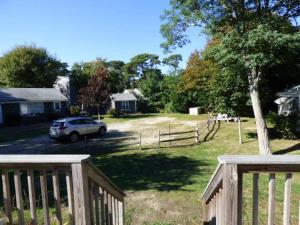 ein Auto, das auf einem Hof mit einem Zaun parkt in der Unterkunft Willows Cottage East in Dennis Port + 4 Fotos