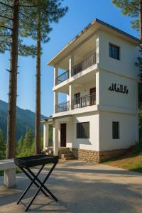a building with a table in front of it at Elite 5BR Escape Home Theater,BBQ,Rooftop Scenic Hills in Naka