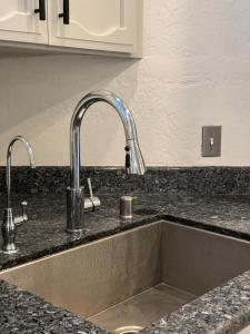 a kitchen sink with two faucets on top of it at Modern Home with Full Gym & Personal garden in San Jose