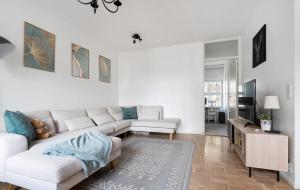 Una sala de estar blanca con un sofá y un televisor. en Place at the Bottom of the Lake, en Helsinki