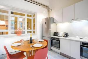 a kitchen with a wooden table and red chairs at Elegantis Monti Royal Apartment with private terrace in Rome