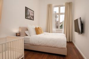 a white bedroom with a bed and a window at Wohnkultur - Altbau Charme für 8 Personen in Mannheim