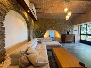 a living room with two couches and a table at Relais Portaluna delle Langhe, Private Estate with Pool, 7 Bedrooms, Sleeps 18, Vineyard Views in Mango