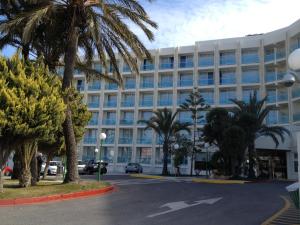 een groot wit gebouw met palmbomen ervoor bij Evenia Zoraida Resort in Roquetas de Mar