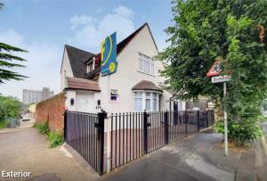 un edificio con una valla delante en Delightful 1-Bedroom Apartment with Garden, en South Norwood