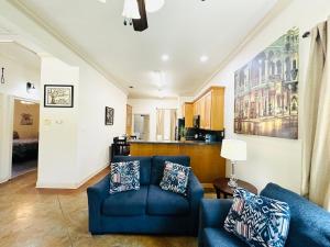 a living room with two blue couches and a kitchen at Villa 3 in Hammond