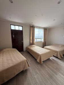 a bedroom with two beds and a window at Laguna Azul Tacna in Tacna