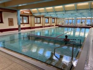 a person is standing in a large swimming pool at La Ruinette-stylish 2-bed With Pool & Gym Access in Verbier