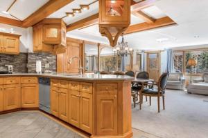 a kitchen with wooden cabinets and a dining room at Lodge Tower 387 Three Bedroom Residence in Vail