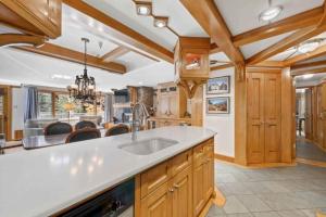 a large kitchen with wooden cabinets and a sink at Lodge Tower 387 Three Bedroom Residence in Vail +27 photos