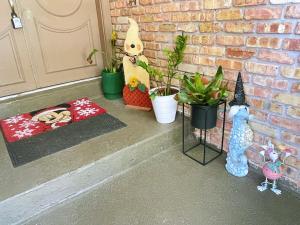 a porch with plants and a door with a cat figurine at Happy Home in Orlando
