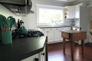 a kitchen with white cabinets and a stove top oven at Charming Home On The Point in Newport