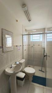a bathroom with a toilet and a sink and a shower at Pousada Recanto do Sossego in São Thomé das Letras +95 photos