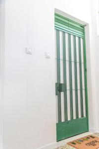 a green door on a white wall with a rug at 5 steps from the sea in Kalamata +52 photos