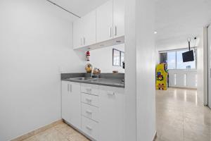 Una cocina con gabinetes blancos y un fregadero. en Otium Pool Beach Access, en San Juan 40 fotos más