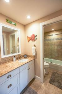 a bathroom with a sink and a toilet and a mirror at Upgraded and Spacious Harbor Towers Condo! Siesta Key Vacation! in Siesta Key