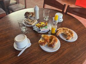 a table with plates of croissants and coffee on it at HSR Termas in Termas de Río Hondo