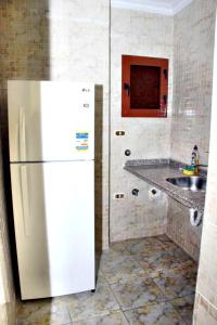 a kitchen with a white refrigerator and a sink at Alexandria Mediterranean Suites in Alexandria