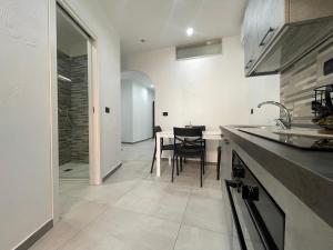 a kitchen with a table and a dining room at La Viuzza Rooms in Barletta