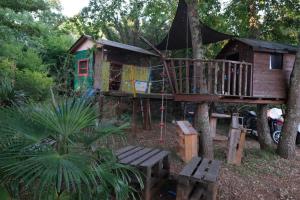 ein Baumhaus im Wald mit einer Bank in der Unterkunft Apartment Andjel in Poreč