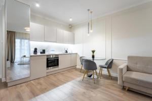 eine Küche und ein Wohnzimmer mit einem Tisch und einer Couch in der Unterkunft Golden Apartments - Luxury Stay for up to 15 Guests in Mennica Residence, Warsaw Center in Warschau