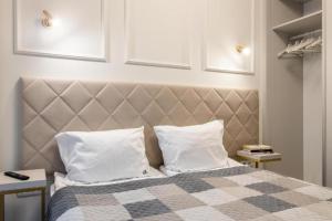 ein Schlafzimmer mit einem Bett mit zwei weißen Kissen in der Unterkunft Golden Apartments - Luxury Stay for up to 15 Guests in Mennica Residence, Warsaw Center in Warschau