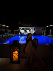 a person with their feet up next to a pool at night at Andruss Motel in Walker +3 photos