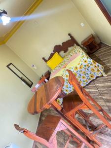 a bedroom with a bed and a wooden chair at Hotel Pousada Mozini's in Tupã +7 photos