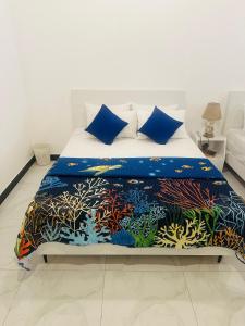 a bedroom with a bed with an aquarium themed bedspread at TJ lanka homestay in Moratuwa