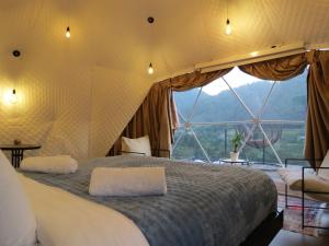 a bedroom with a large bed in a tent at Glamping Daphenili in Tskalt'ashua
