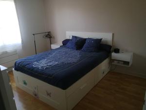 a bedroom with a bed with blue sheets and a window at Maison privée 106m2 avec 3 chambres et jardin in Saint-Médard-en-Jalles