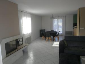 a living room with a couch and a table at Maison privée 106m2 avec 3 chambres et jardin in Saint-Médard-en-Jalles +4 photos