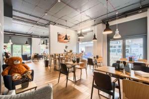 ein Restaurant mit einem großen Teddybär auf einem Stuhl in der Unterkunft Golden Apartments - Luxury Stay for up to 20 Guests in Mennica Residence, Warsaw Center in Warschau