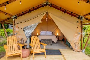 een tent met een bed en twee stoelen bij Cozy Wine Country Retreat at Painted Prairie in Currie