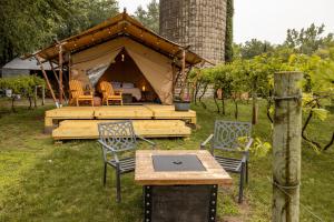 a tent with chairs and a table in front of it at Boutique Vineyard Stay at Painted Prairie in Currie
