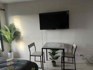 a room with a table and chairs and a tv on the wall at Sezuki JTower Stay in Mandaue City