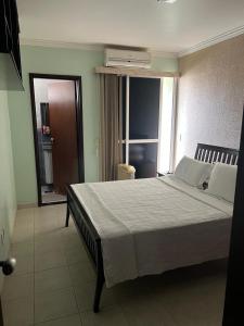 a bedroom with a large bed and a large window at Sobrado com piscina in Caldas Novas
