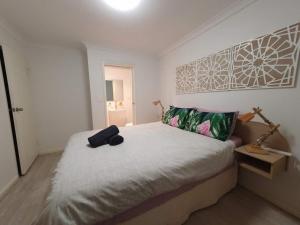 a bedroom with a bed with a black bag on it at Coastal Salty Air 2Bedrm 2Bath w Ocean Views! in Perth