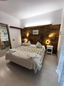 a bedroom with a large bed and a wooden wall at B&B Guglielmina in Quarna Sotto