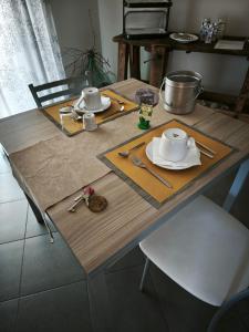 a wooden table with plates and utensils on it at B&B Guglielmina in Quarna Sotto +66 photos