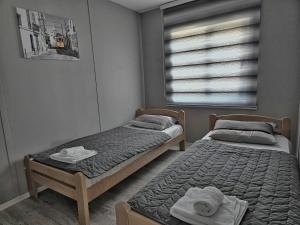 two twin beds in a room with a window at Villa Emili in Ohrid