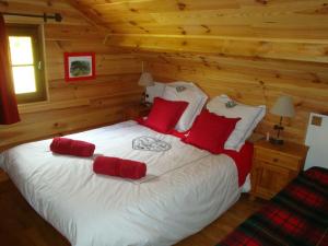 a bedroom with a large white bed with red pillows at Chambres d'hôtes le génépi in Valdeblore