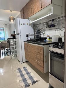 a kitchen with a white refrigerator and a stove at Casa em Condomínio - Salinópolis in Salinópolis