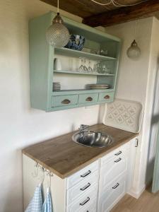 a kitchen with a sink and a green cabinet at Lykkeholms Bella Vista in Spottrup
